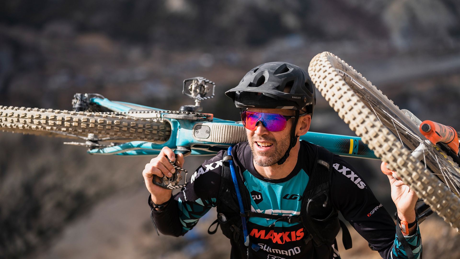 Geoff Kabush carrying his bike and smiling